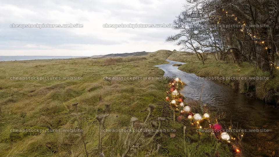 Christmas ornaments along stream in meadow – stock pictures 10584x5952