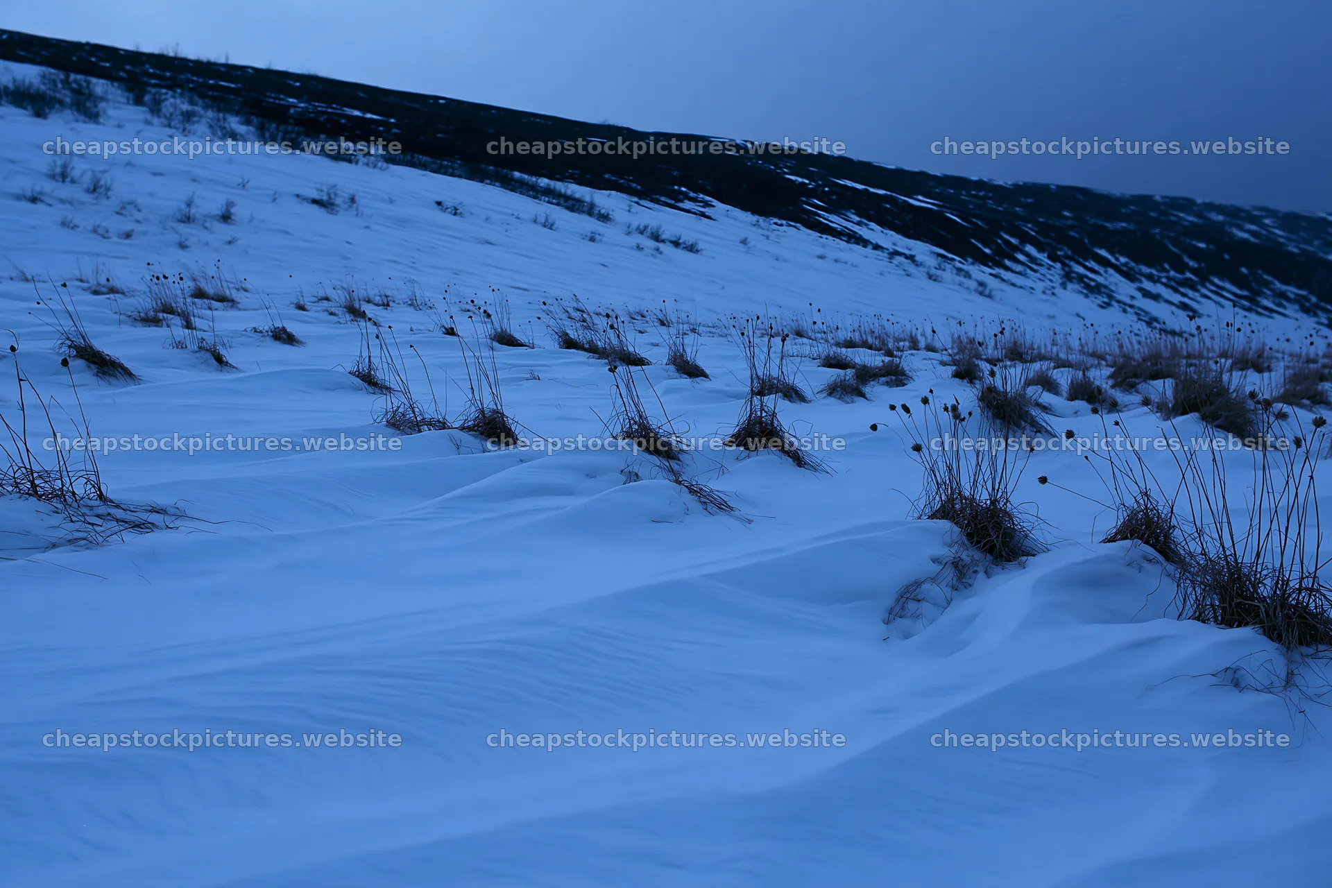 Snowy highland meadow with grass and hills in the distance – stock pictures 9722x6480