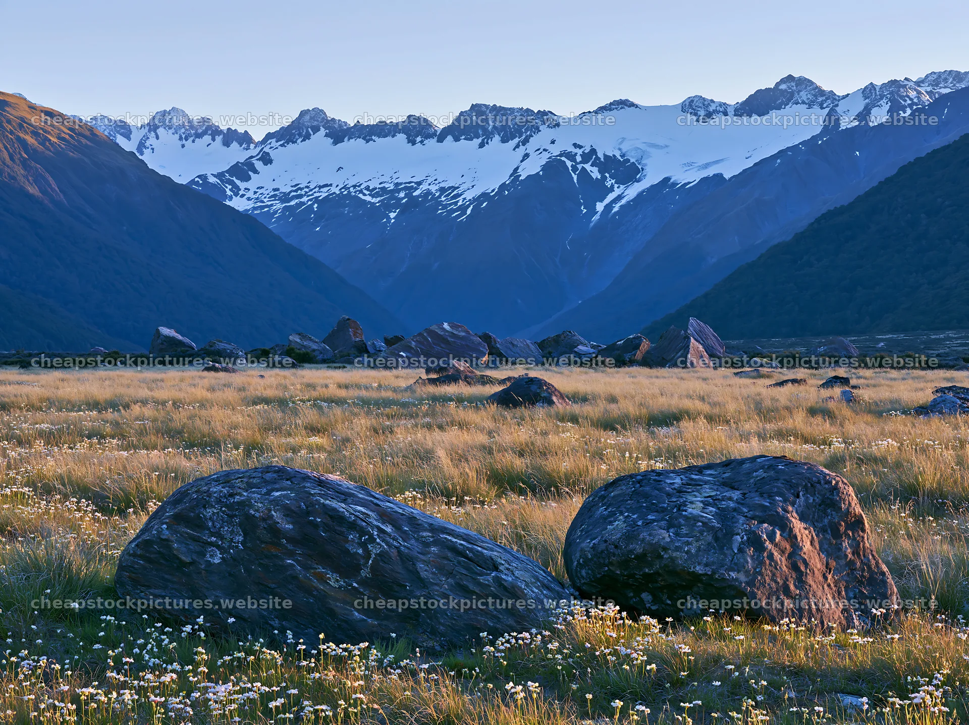 Meadow with boulders and mountains under clear sky – stock pictures 9174x6866