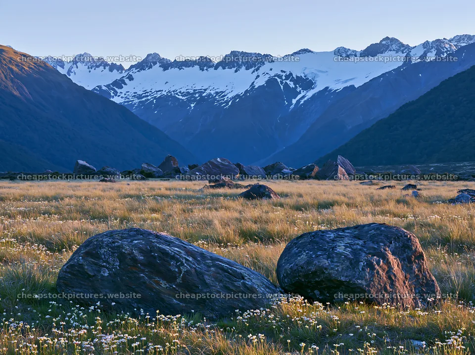 Meadow with boulders and mountains under clear sky – stock pictures 9174x6866