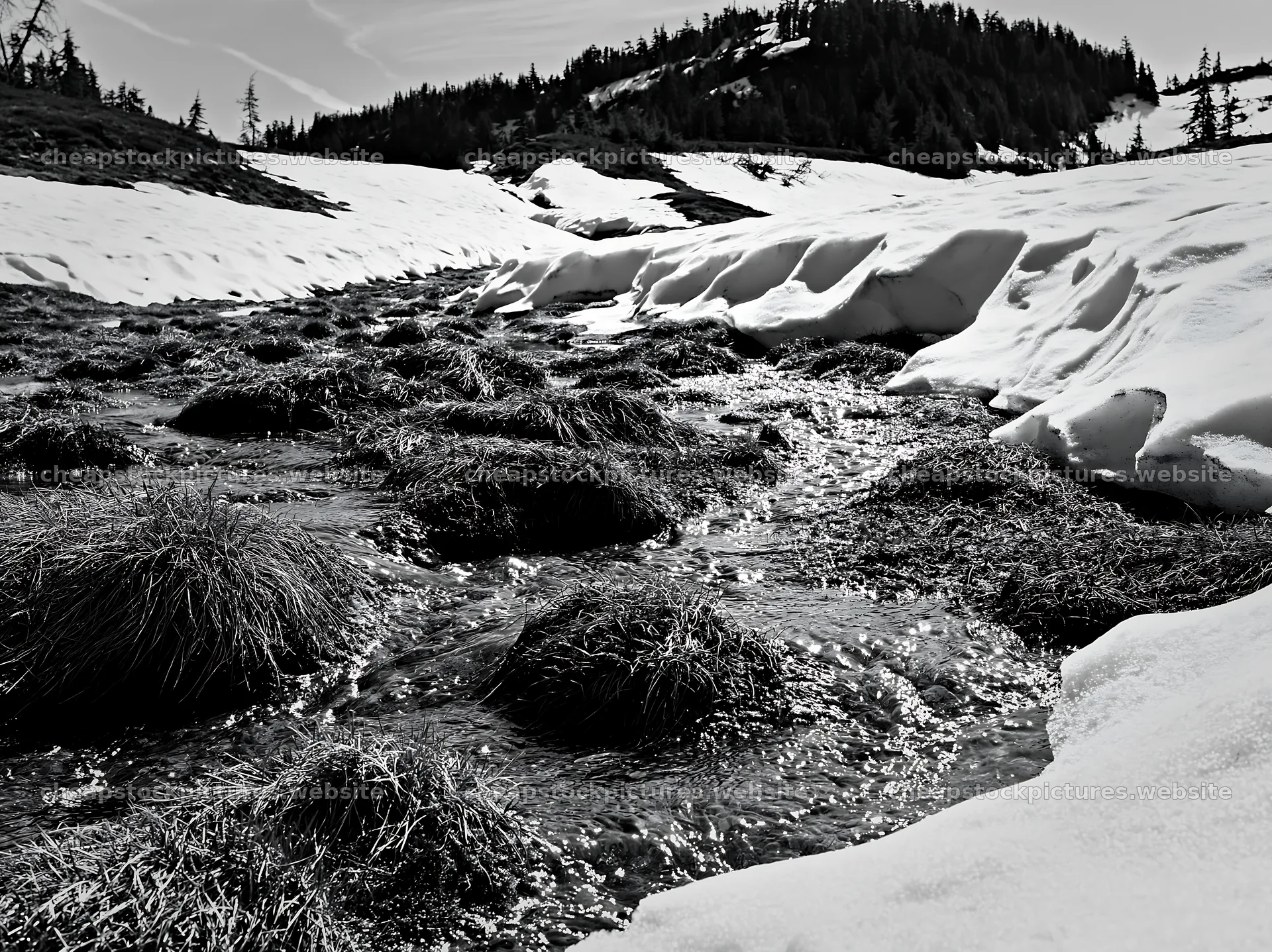Snowmelt stream flowing through a meadow with snow and grass – stock pictures 9174x6866