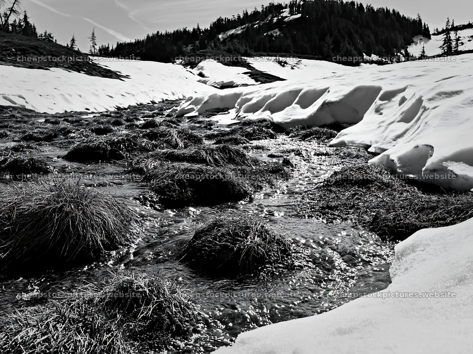 Snowmelt stream flowing through a meadow with snow and grass – stock pictures 9174x6866