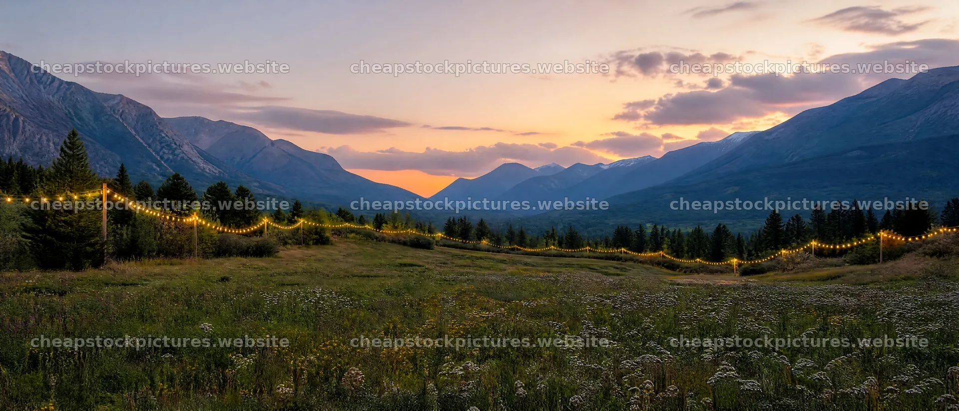 Warm Christmas lights across mountain valley meadow at sunset – stock pictures 12124x5196