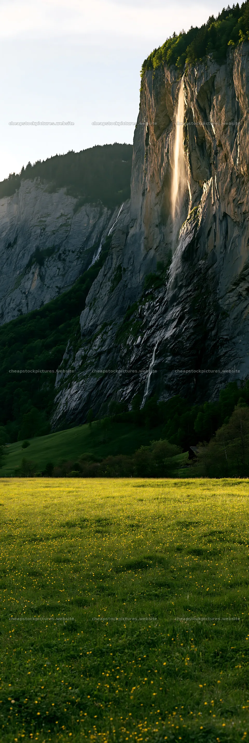 Lauterbrunnen Valley meadow with sunlight on cliffs and waterfall – stock pictures 4602x13690