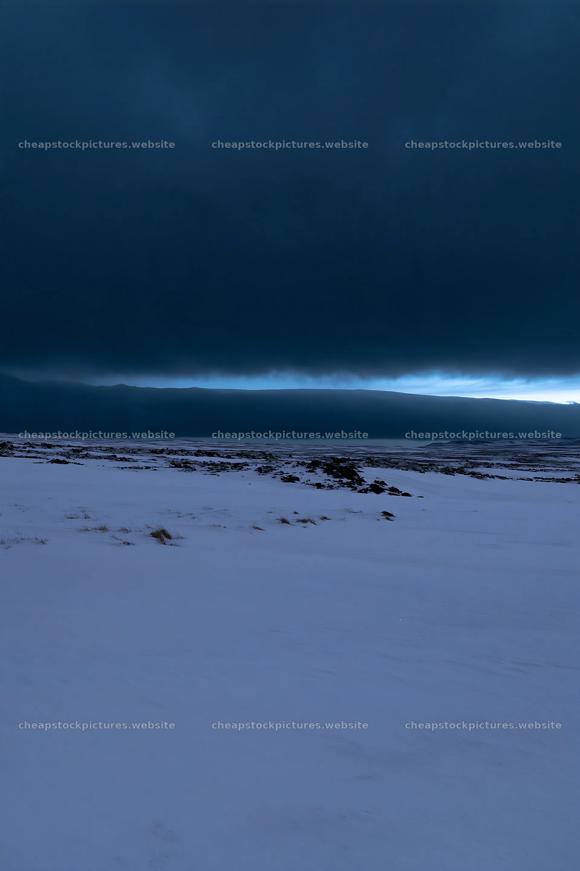 Snowbound meadow under dark clouds during twilight – stock pictures 6480x9722