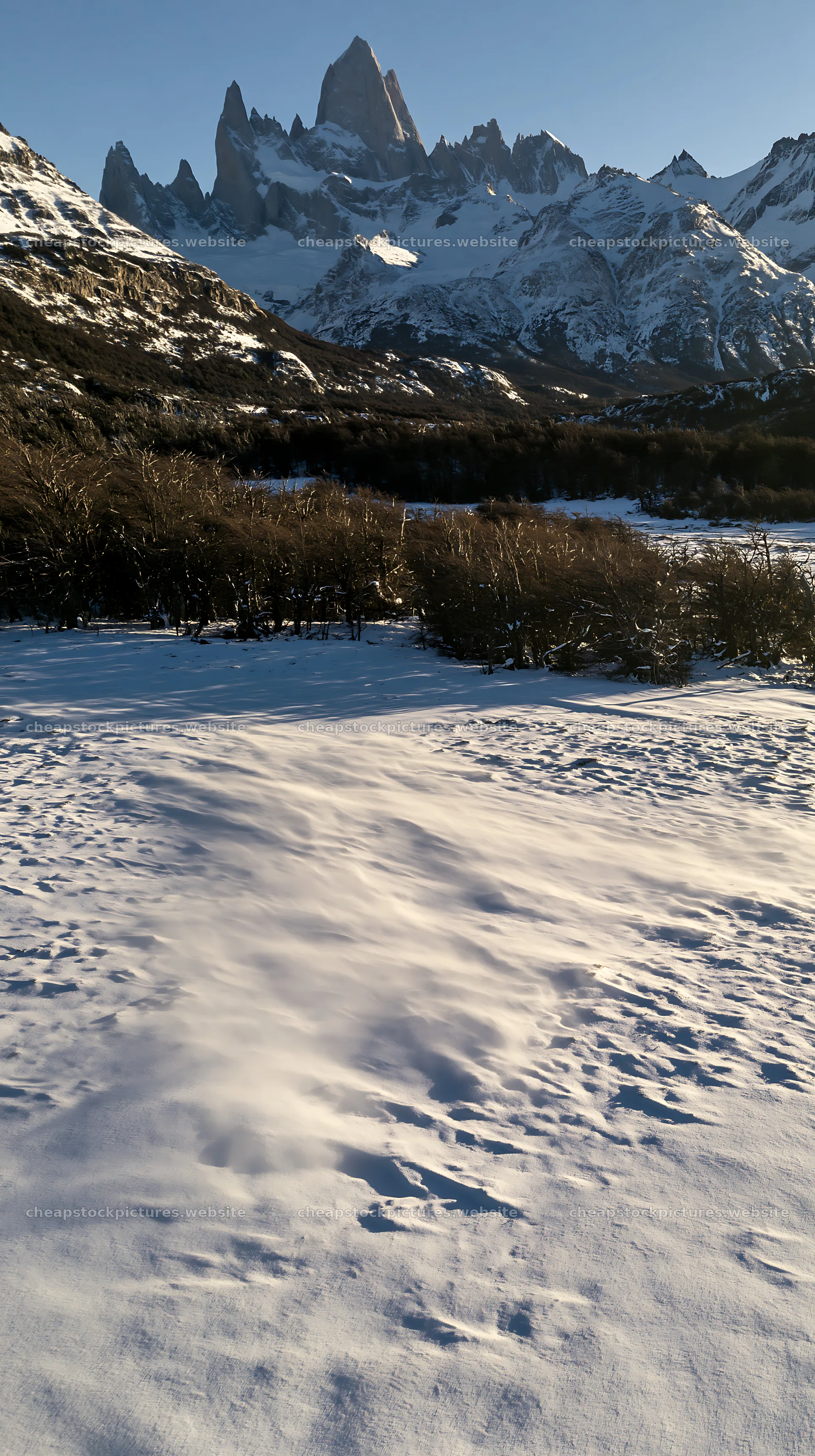Aerial view snowy meadow valley with mountains in the background – stock pictures 5938x10608
