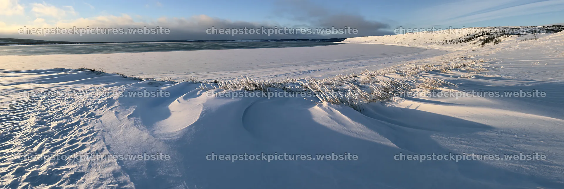 Snowy lakeside meadow under clear sky in winter – stock pictures 13690x4602